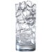 A tall clear glass filled with half dice cube ice.