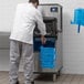 A commercial ice machine with a person scooping ice into a blue bucket labeled 'ICE ONLY'.