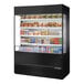 A 60-inch refrigerated air curtain merchandiser with glass sides, stocked with assorted food and beverages.