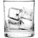 A clear glass filled with several medium-sized ice cubes.
