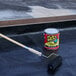 A can of Flex Seal black liquid rubber sealant coating with a paint roller being used to apply it.
