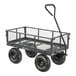 A steel utility cart with mesh sides, four large wheels, and a pull handle.