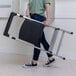 A person carrying a folded aluminum 2-step folding project step stool.