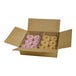 A cardboard box containing an assortment of donuts, including pink frosted donuts with sprinkles and glazed donuts.
