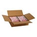 A cardboard box containing two plastic-wrapped trays of pink iced donuts with sprinkles.