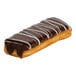 A rectangular donut topped with chocolate icing and white drizzle, filled with buttercreme.