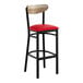 A bar stool with a black metal frame, red vinyl seat, and a driftwood-finished wooden backrest.