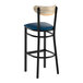 A black metal bar stool with a navy vinyl seat and a driftwood-finished wooden backrest.