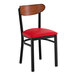 A black metal chair with a red vinyl seat and an antique walnut wood backrest.