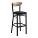 A black bar stool with a black vinyl seat and a driftwood-finished wooden backrest.