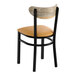A black metal chair with a light brown vinyl seat and a driftwood-finished curved wooden backrest.
