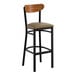 A bar stool with a black metal frame, taupe vinyl seat, and a curved vintage wood backrest.