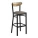 A black bar stool with a dark gray vinyl seat and a driftwood-finished wooden backrest.
