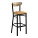 A black metal bar stool with a light brown vinyl seat and a driftwood-finished wooden backrest.