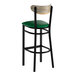 A bar stool with a black metal frame, green vinyl seat, and a driftwood-finished wooden backrest.