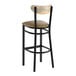 A bar stool with a black metal frame, taupe vinyl seat, and a driftwood-finished curved backrest.