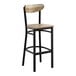 A bar stool with a black metal frame and driftwood-finished wooden seat and backrest.