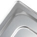 A close-up of a stainless steel slotted cover on a metal tray.