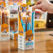 A box of Archer Original Beef Sticks, each individually wrapped, displayed on a counter with one stick being picked up by a hand.