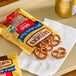 A small bag of Snyder's of Hanover Mini Pretzels with several pretzels spilled onto a napkin.