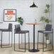 A pair of modern high-back barstools with black steel frames and gray faux leather upholstery.