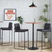 A pair of high-back barstools with black steel frames and black faux leather seats and backs.