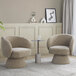 A pair of light brown fabric swivel accent arm chairs with pedestal bases are positioned around a small round side table in a modern living room setting.