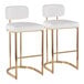 A pair of barstools with gold metal frames and white faux leather seats and backs.