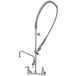A T&S chrome wall mounted pre-rinse faucet with a hose.