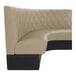 A large, curved booth with diamond tufted fawn upholstery and a black base.