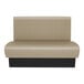 A beige upholstered double back booth with a black base, designed for commercial seating.