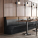 A 30-inch long, 36-inch high cafe booth with a single back and head roll, upholstered in two-tone material.