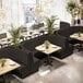 A long, ebony-colored, 3/4 circle booth with channel tufting and a 36-inch high back, designed for restaurant seating.