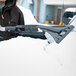 A 3-in-1 folding emergency snow shovel with an aluminum blade, ice scraper, and brush being used to clear snow from a vehicle.