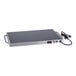 A rectangular stainless steel warming shelf with a black surface, side handles, and an attached power cord.