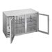 A stainless steel underbar height back bar refrigerator with glass doors and interior shelving.