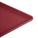 A close-up of a red Cambro dietary tray with a handle.