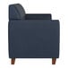 A navy blue leather sofa with wooden feet and a boxy, modern design.
