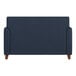 A navy blue loveseat with wooden feet and a smooth backrest.