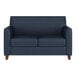 A navy blue loveseat with wooden feet and a modern, boxy design.