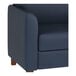 A navy blue loveseat with wooden feet and a smooth, cushioned design.