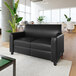 A black leather loveseat with wooden feet and a built-in charging bank, placed in a modern office setting.
