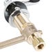 A close-up of a brass and chrome T&S deck-mount faucet with gooseneck and wrist action handles.