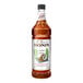 A 1-liter bottle of Monin Premium Toasted Coconut Flavoring Syrup.