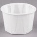 A white Solo paper souffle cup with a lid on a gray surface.