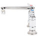 A close-up of a chrome T&S deck-mount faucet with two silver handles and a blue label on one handle.