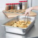 A stainless steel pan grate holding food over a metal tray.