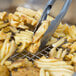 Vollrath stainless steel wire pan grate holding French fries with tongs.