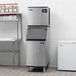 A commercial stainless steel ice machine with a storage bin, designed for producing and storing ice cubes.