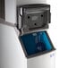 A commercial ice machine with an open storage bin and ice scoop visible inside.